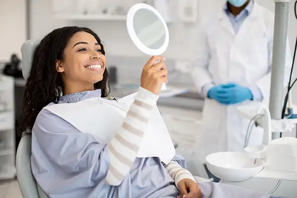 Black woman in dental chair smiling that she longer has tooth loss thanks to  Martin Periodontics in Mason, OH