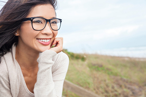 Smiling woman with glasses enjoying the outdoors after gum graft surgery at Martin Periodontics in Mason, OH
