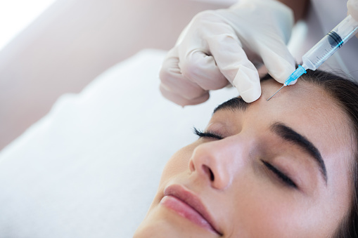 A woman receving Botox injections from a doctor Martin Periodontics in Mason, OH