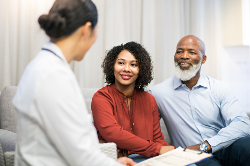 Older Black couple speaking with dentist at Martin Periodontics in Mason, OH
